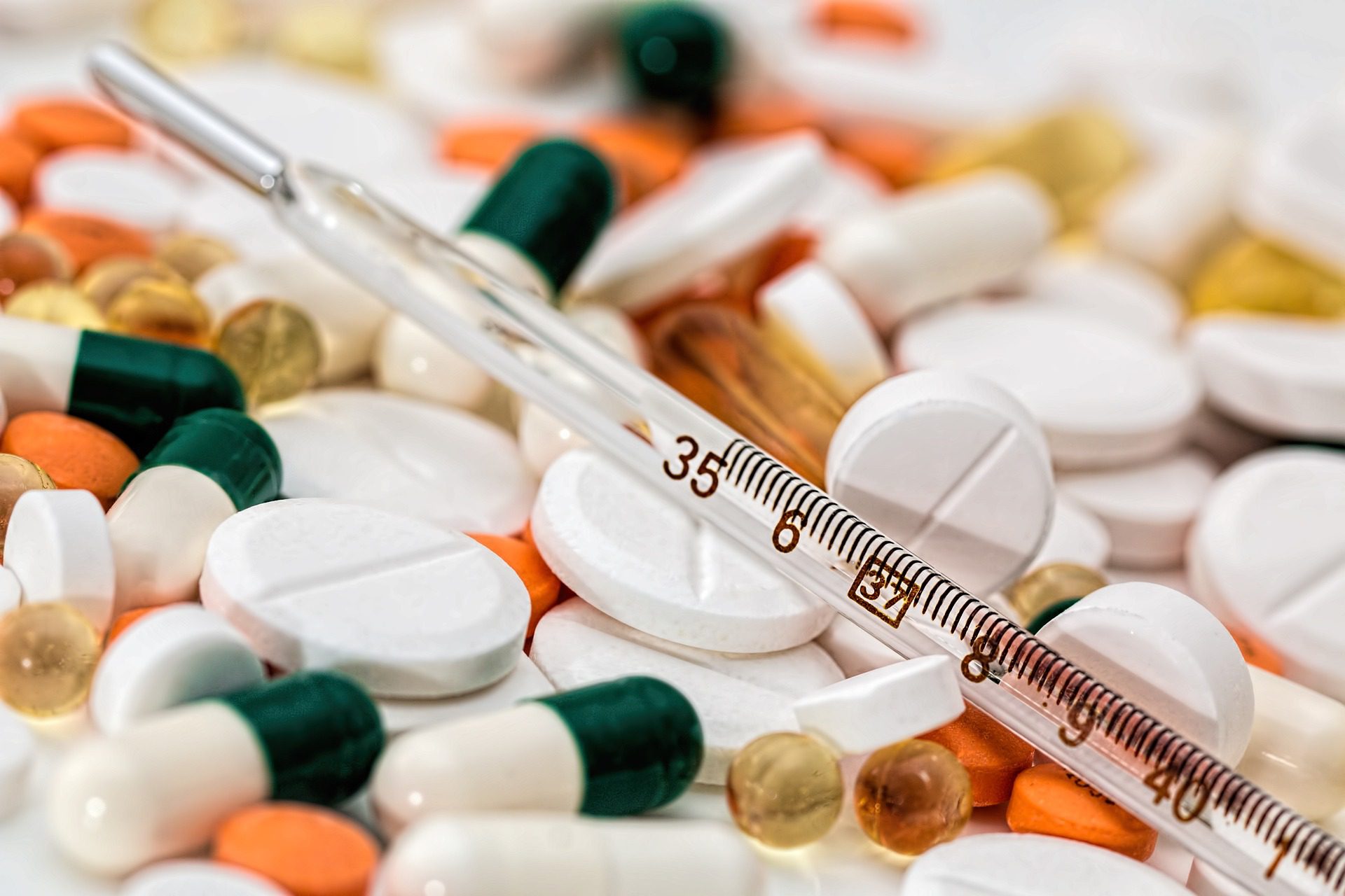 Many pills along with a thermometer represent our world's relationship with prescription drugs and over-the-counter substances.