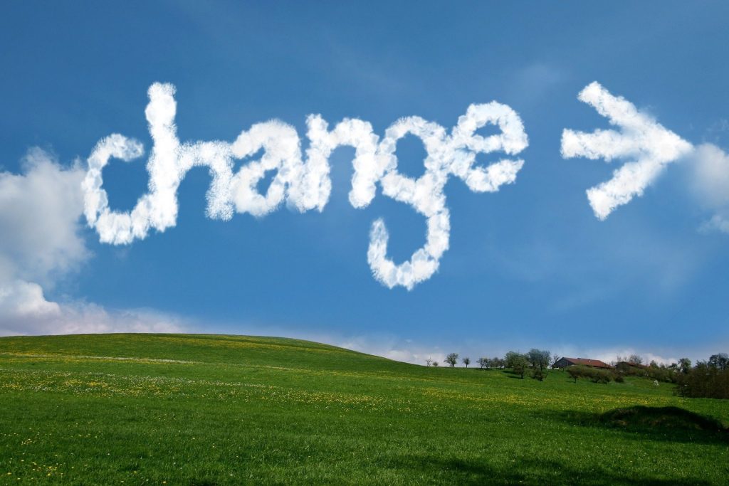 Where lands are green and skies are blue, the word "Change" appears in the clouds with an arrow pointing the way.